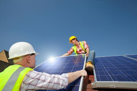 Men installing solar panels on roof