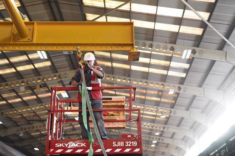 ilke Homes factory worker on scissor lift